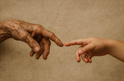 Zwei sich beinahe berührende Hände inspiriert von Michelangelos Erschaffung Adams - Alt und Jung