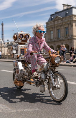 Exzentrischer Mann mit blauer Sonnenbrille und Roboter auf einem Tandem in Paris